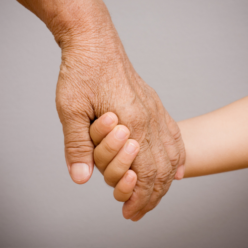 Dłoń starszej osoby trzymająca dłoń dziecka